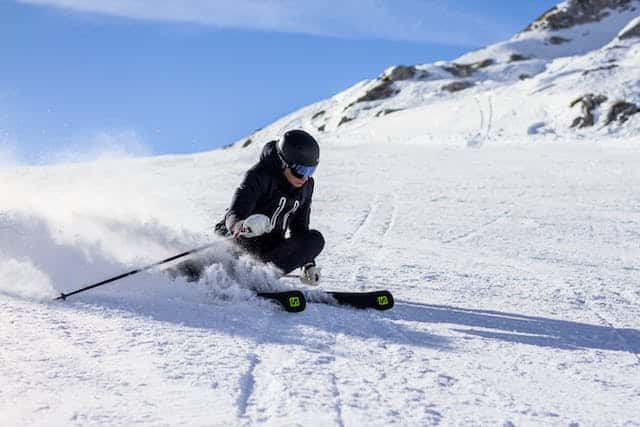 Skieur réalisant un virage sur une piste enneigée