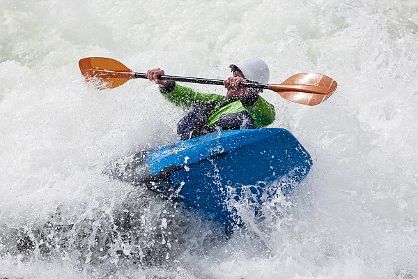 assurance kayak cross un kayakiste masculin actif qui roule et surfe dans des eaux agitées