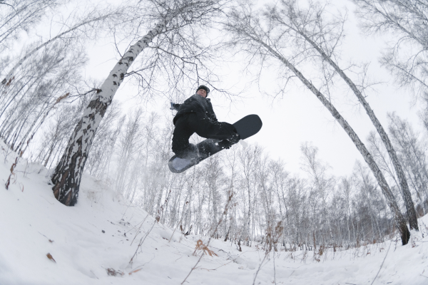 homme qui fait du ski hors piste en foret en plein saut